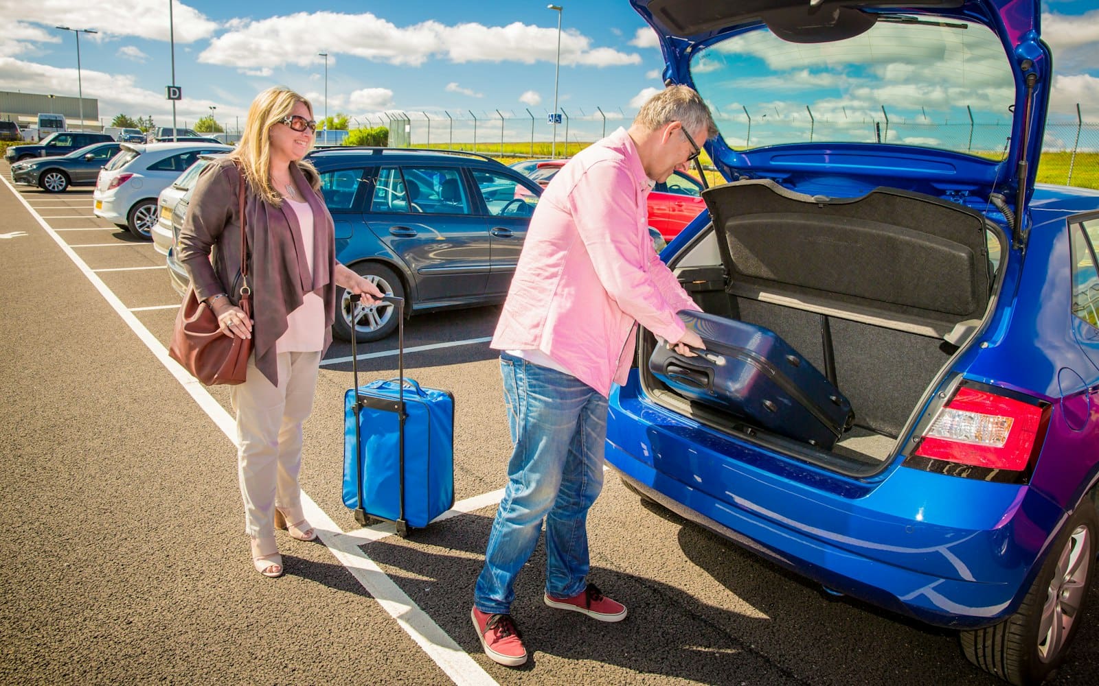 Couple loading luggage into a car